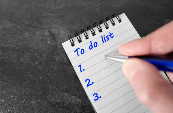 手書きの仕事の閉鎖でビジネスプランの概念をリストを行うには背景に暗い灰色のテーブルのノートブック上に青いペンで注文リスト — ストック写真