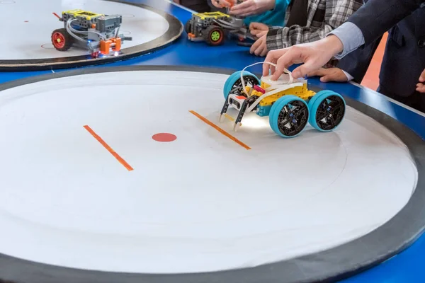 Bilim fuarında bir yarışma yüzüğünde DIY robotu başlatan bir öğrencinin yakın çekimi..