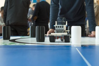 Eğitimli robot, kapalı alandaki bir robotik yarışmasında engelli bir pistte yol alıyor. Teknoloji, BTMM öğrenme, mühendislik, yenilik. bowling ringi yarışması