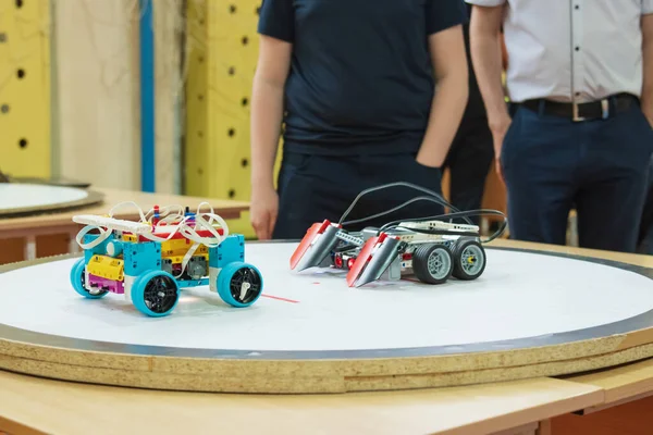 İki eğitici robot kapalı alanda dairesel bir arena masasında yarışıyor. Robot yarışması sırasında sensörlü ve kontrollü otonom robotlar. BTMM eğitimi, mühendislik, teknoloji