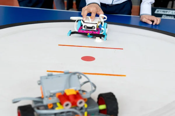 Kadın ellerini robotla kapat. Bir öğrenci ya da öğretmen plastik yapı taşlarıyla yapılmış küçük, renkli, programlanabilir bir robotu ayarlıyor.