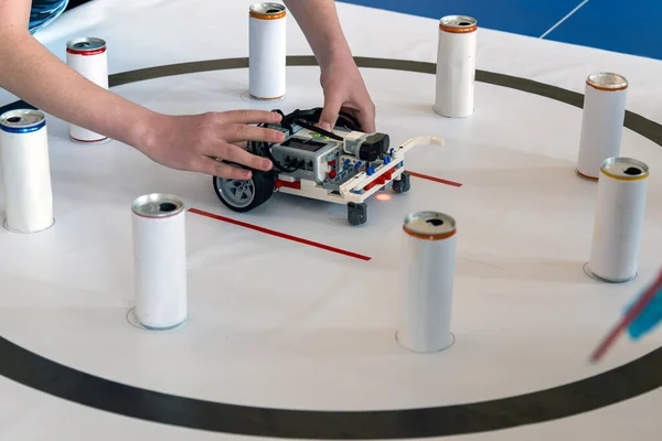 Kadın ellerini robotla kapat. Bir öğrenci ya da öğretmen plastik yapı taşlarıyla yapılmış küçük, renkli, programlanabilir bir robotu ayarlıyor.