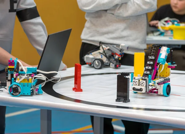 Öğrenci çocuk gelişmiş bir eğitim robotunu programlıyor. Okul üniformalı bir öğrenci dizüstü bilgisayarla bir masada oturur ve kompleks programlanabilir robot setini kodlamaya ve yapılandırmaya odaklanır. BTMM eğitimi ve modern okul temaları için mükemmel