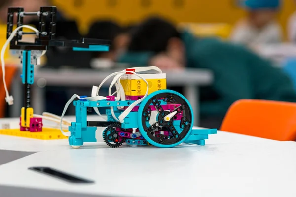 LEGO Education SPIKE Prime bileşenlerinden oluşturulmuş özel yapım bir robotun eğitim amaçlı bir robot projesinin yakın plan çekimi. Robot öncelikle programlanabilir bir merkeze sahip parlak turkuaz, mor ve sarı parçalardan oluşur.