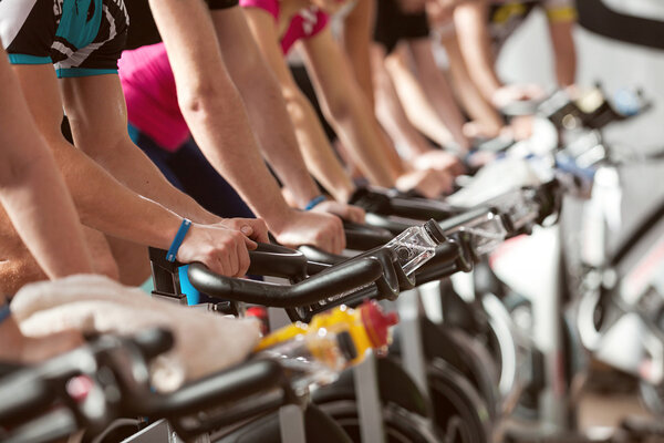 Gym detail shot, people cycling, spinning class