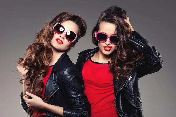 Sisters twins in hipster sun glasses laughing Two fashion models — Stock Photo, Image