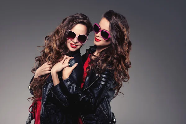 Nővérek ikrek két divat modellek nevetve csípő napszemüvegek — Stock Fotó