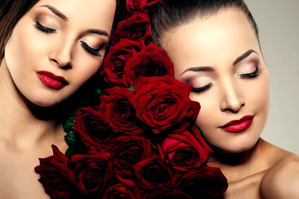 Zwei schöne junge Frauen mit fantastischem Make-up in Rosen. Kosmeti — Stockfoto