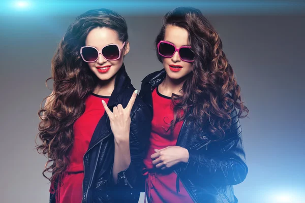 Hermanas gemelas con gafas de sol hipster riendo. Dos modelos de moda —  Fotos de Stock
