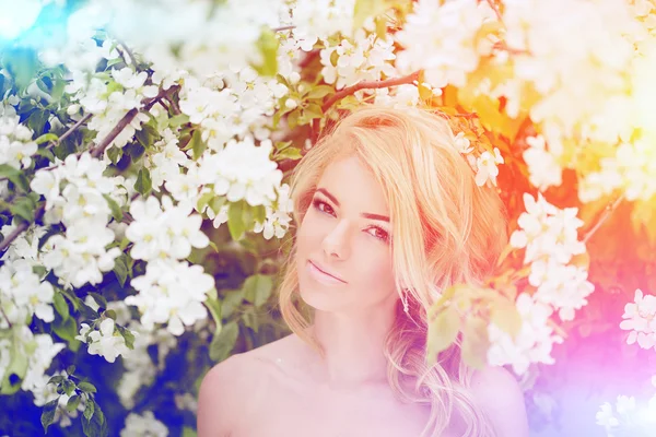 Junge Frühlingsmode Frau. trendiges Mädchen in den blühenden Bäumen — Stockfoto