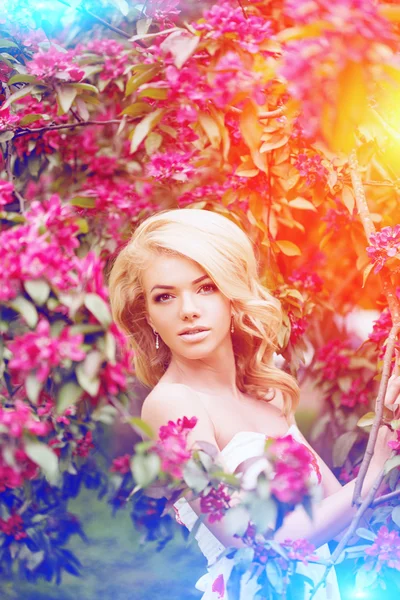 Young spring fashion woman. Trendy girl in the flowering trees i — Stock Photo, Image
