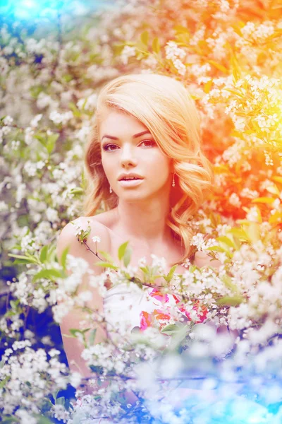 Young spring fashion woman. Trendy girl in the flowering trees i — Stock Photo, Image