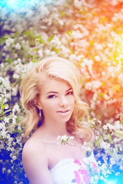 Joven mujer de moda de primavera. Chica de moda en los árboles con flores i —  Fotos de Stock