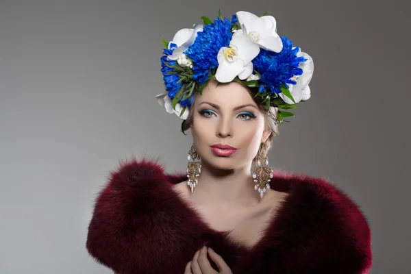 Woman with a wreath of flowers on her head in a fur coat. Young Rechtenvrije Stockafbeeldingen