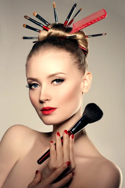 Belleza joven modelo estilista con cepillos en el peinado de volumen Imágenes de stock libres de derechos