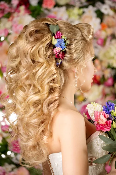 Penteado de casamento uma jovem. Noiva. Mulher com flores em seu — Fotografia de Stock