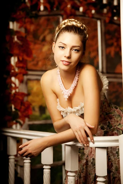 Junge schöne Frau im Vintage-Kleid auf der Veranda im Herbst. Schönheit g — Stockfoto