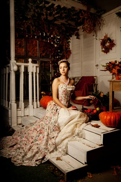 Jeune belle femme en robe vintage sur le porche d'automne. Beauté g — Photo