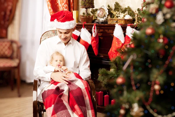 Noel ağacının etrafında oturan aile. Baba ve bebek ne — Stok fotoğraf
