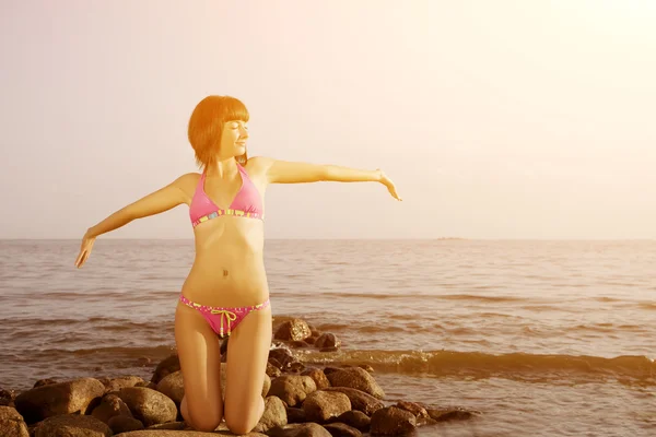 Mujer joven en bikini en la playa con las manos en alto. Chica con —  Fotos de Stock