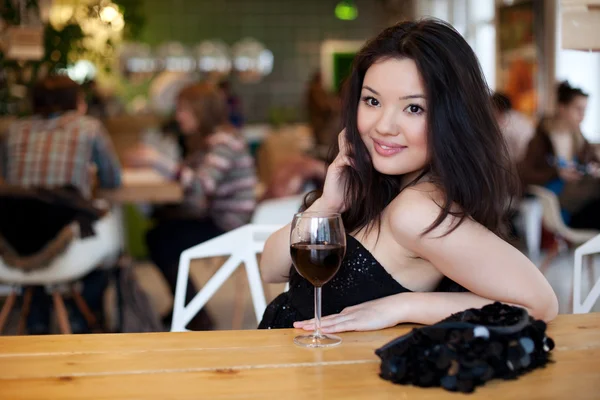 Young beautiful trendy woman in bar. Beautiful Asian girl in a p — Stock Photo, Image