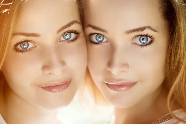 Des jumeaux. Un groupe de jeunes belles filles. Deux femmes font face à un gros plan — Photo