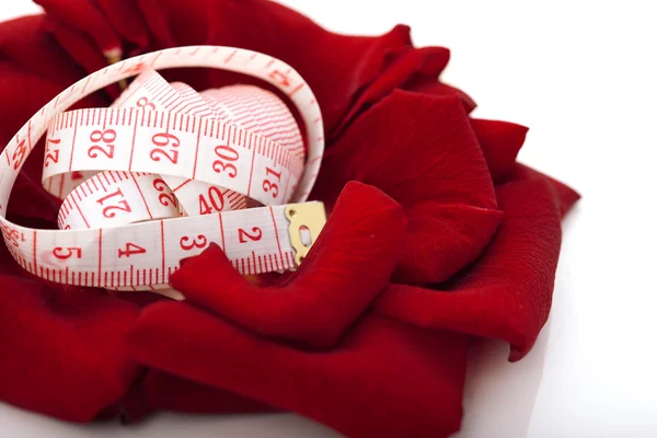 Concepto de dieta. cinta métrica aislada en pétalos de rosa flor i —  Fotos de Stock