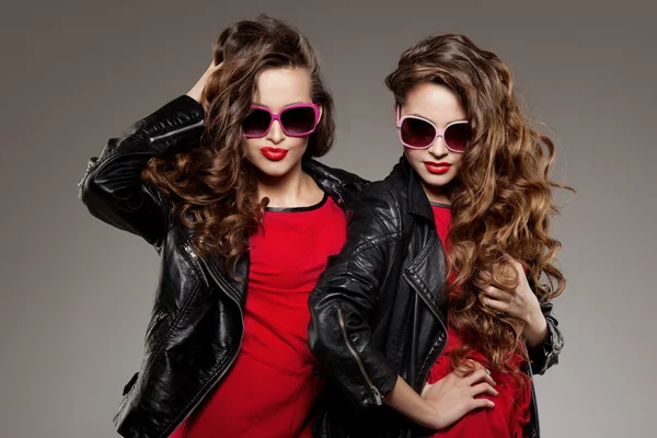 Sisters twins in hipster sun glasses laughing Two fashion models — Stock Photo, Image