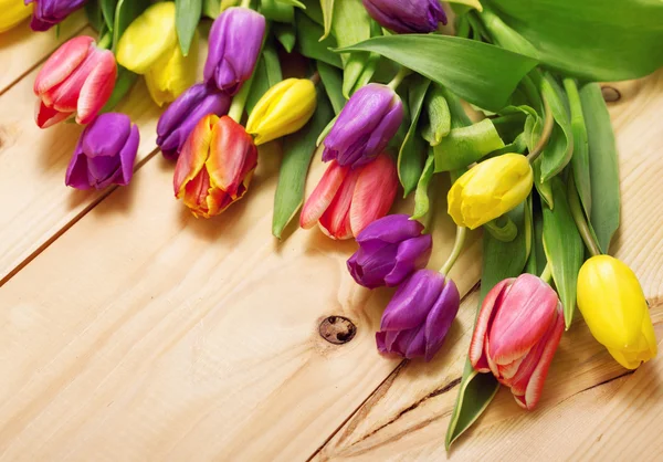 Lentebloemen bos op houten vloer textuur. Mooie tulpen bou — Stockfoto