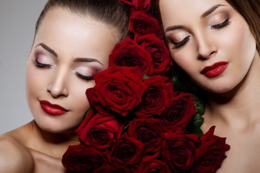 Two beautiful young women with amazing make-up in roses. Cosmeti