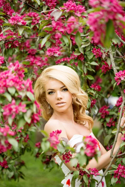 Jonge lente mode vrouw. Trendy meisje in de bloeiende bomen ik — Stockfoto