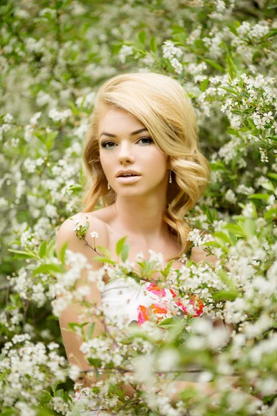 Jonge lente mode vrouw. Trendy meisje in de bloeiende bomen ik — Stockfoto