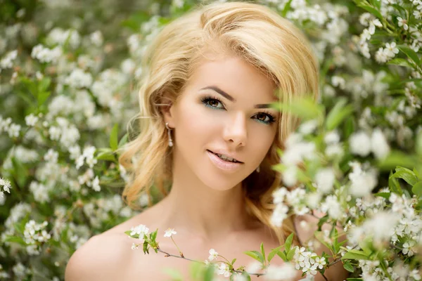Junge Frühlingsmode Frau. trendiges Mädchen in den blühenden Bäumen — Stockfoto