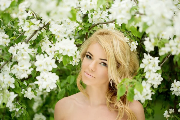 Giovane donna di moda primaverile. Ragazza alla moda tra gli alberi in fiore i — Foto Stock