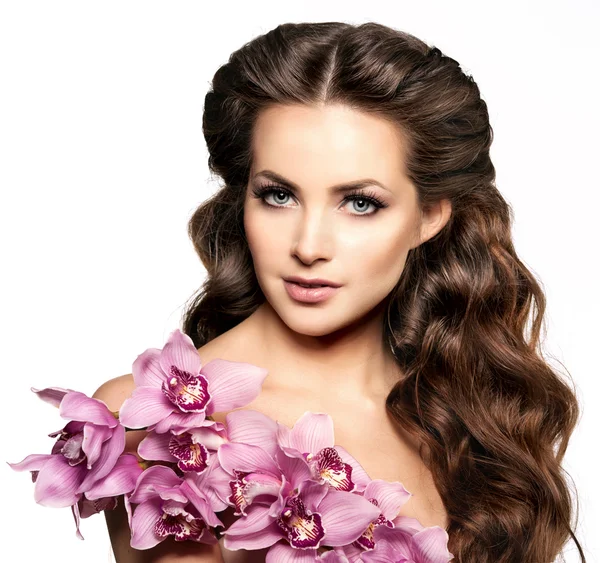 Bellezza giovane donna, lusso lunghi capelli ricci con fiore di orchidea. H — Foto Stock