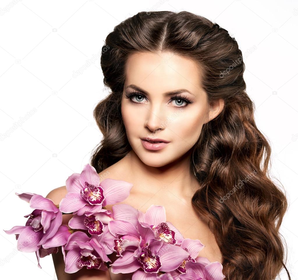 Beauty young woman, luxury long curly hair with orchid flower. H