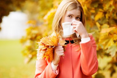 Girl with cold rhinitis on autumn background. Fall flu season. I