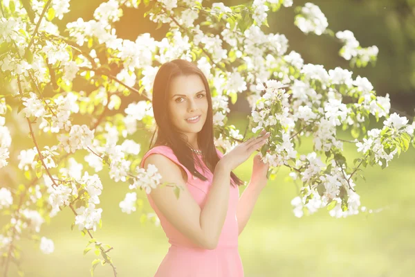 Young spring fashion woman. Trendy girl in the flowering trees i — Stock Photo, Image