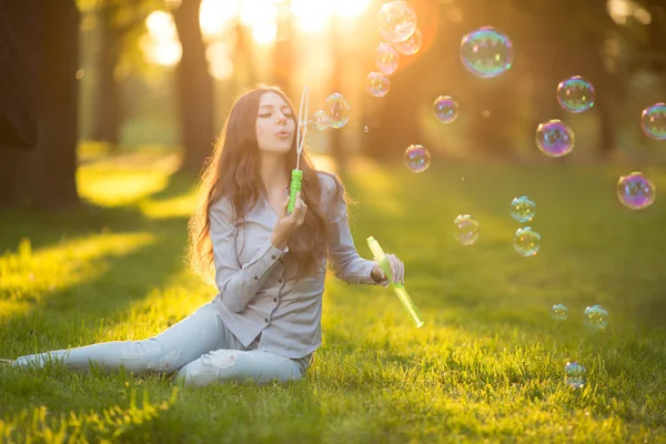 Jovem primavera moda casual mulher bolhas de sopro no por do sol em — Fotografia de Stock