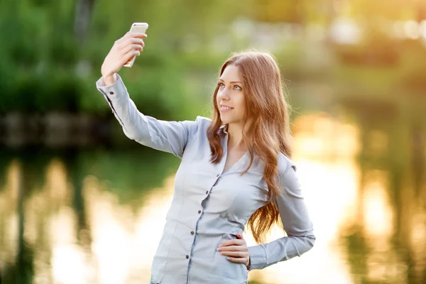 Chica joven romántica sosteniendo una cámara digital smartphone con su — Foto de Stock