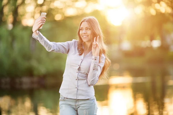 Chica joven romántica sosteniendo una cámara digital smartphone con su — Foto de Stock