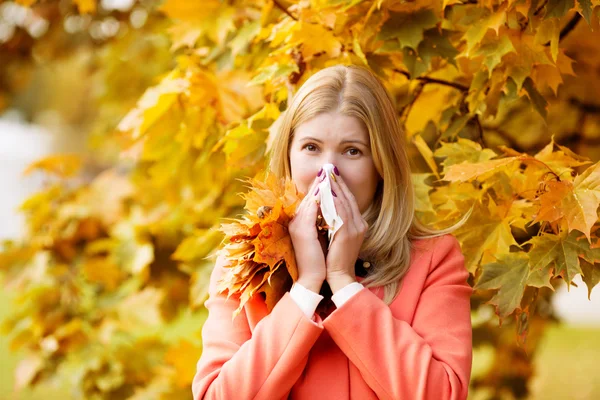 Girl with cold rhinitis on autumn background. Fall flu season. I — Stockfoto
