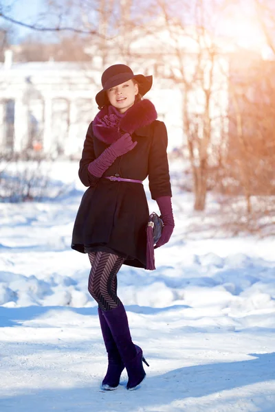 Vinter kvinna på bakgrund av vinterlandskap, solen. Mode flicka Stockbild