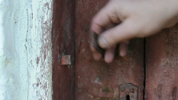 Hand wordt gesloten en oude houten deur open met een ijzeren klink — Stockvideo