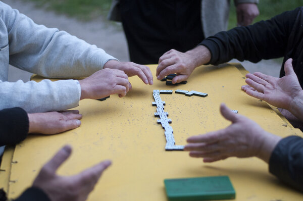 Мужчины играют в домино за столом
