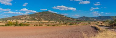 Panoramic view over the landscape with fields, blue sky, beautiful clouds of La Mancha, Spain