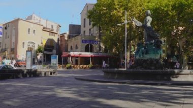 Agde, Fransa - 19 Ağustos 2020: Agde Center 'da eski binalar ve çeşmede bir heykel, şehir manzarası