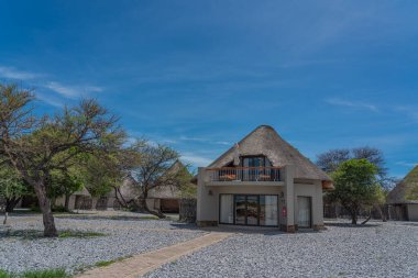 OKAUKUEJO, NAMIBIA - 14 Ocak 2020: Okaukuejo sazdan çatı evleri ve Etosha Milli Parkı 'ndaki kamp alanı