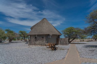 OKAUKUEJO, NAMIBIA - 14 Ocak 2020: Okaukuejo sazdan çatı evleri ve Etosha Milli Parkı 'ndaki kamp alanı