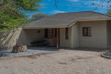 OKAUKUEJO, NAMIBIA - 14 Ocak 2020: Okaukuejo sazdan çatı evleri ve Etosha Milli Parkı 'ndaki kamp alanı